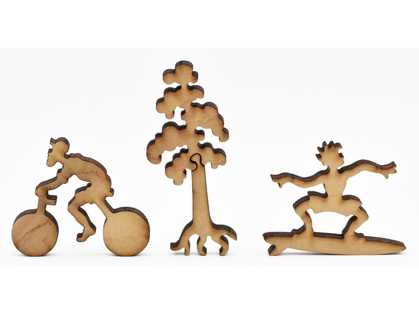 A closeup of pieces in the shape of a cyclist, a tree, and a surfer.
