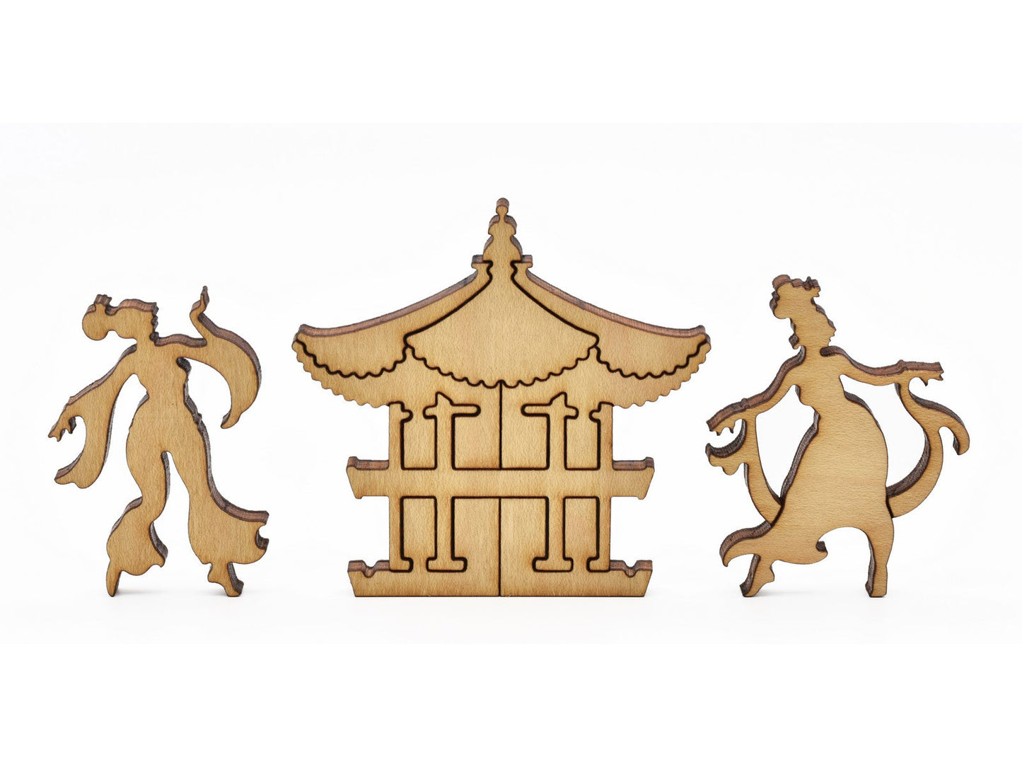 A closeup of pieces in the shape a pagoda and two dancers.