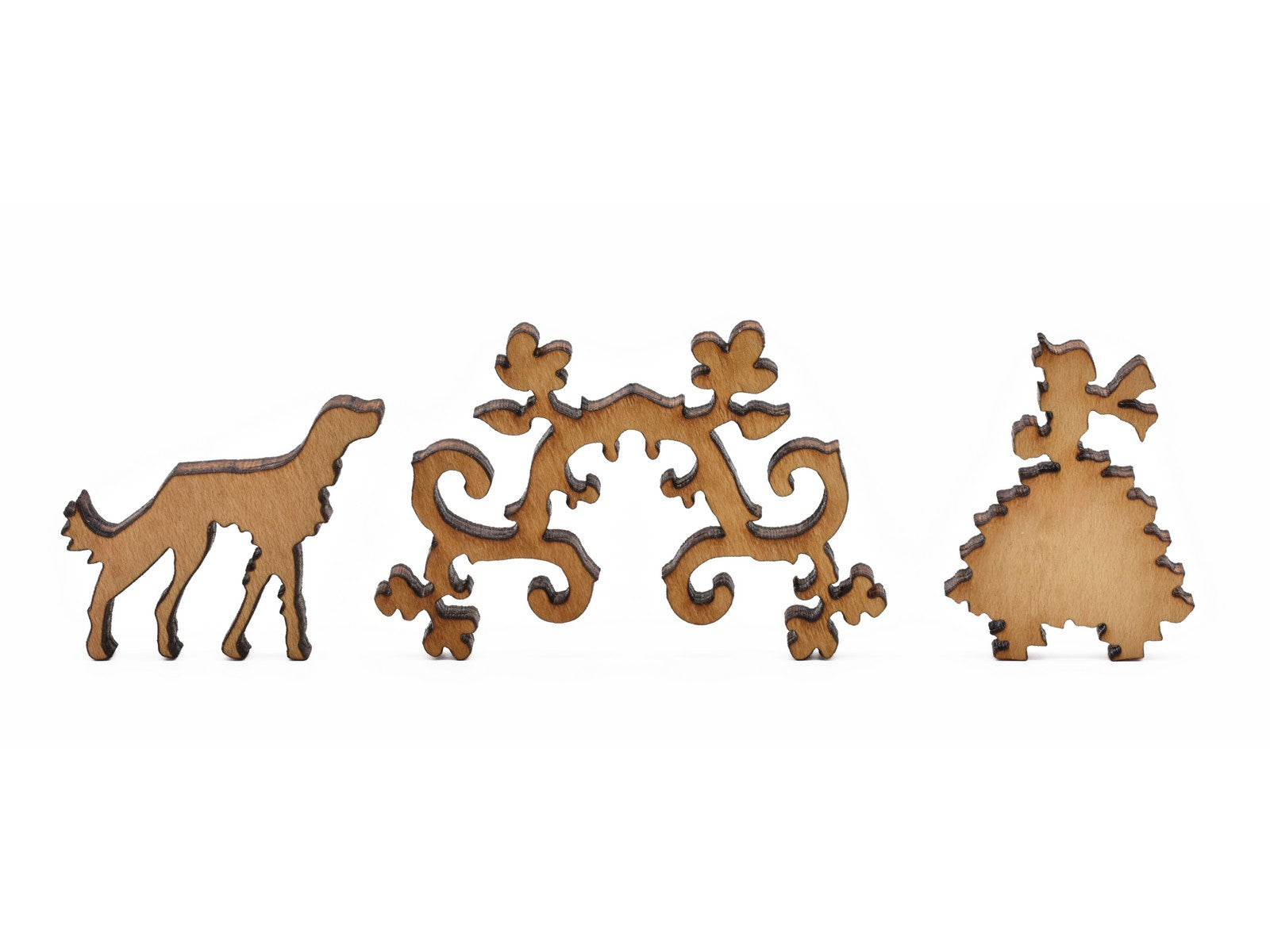 A closeup of pieces in the shape of a dog, vines, and a woman.