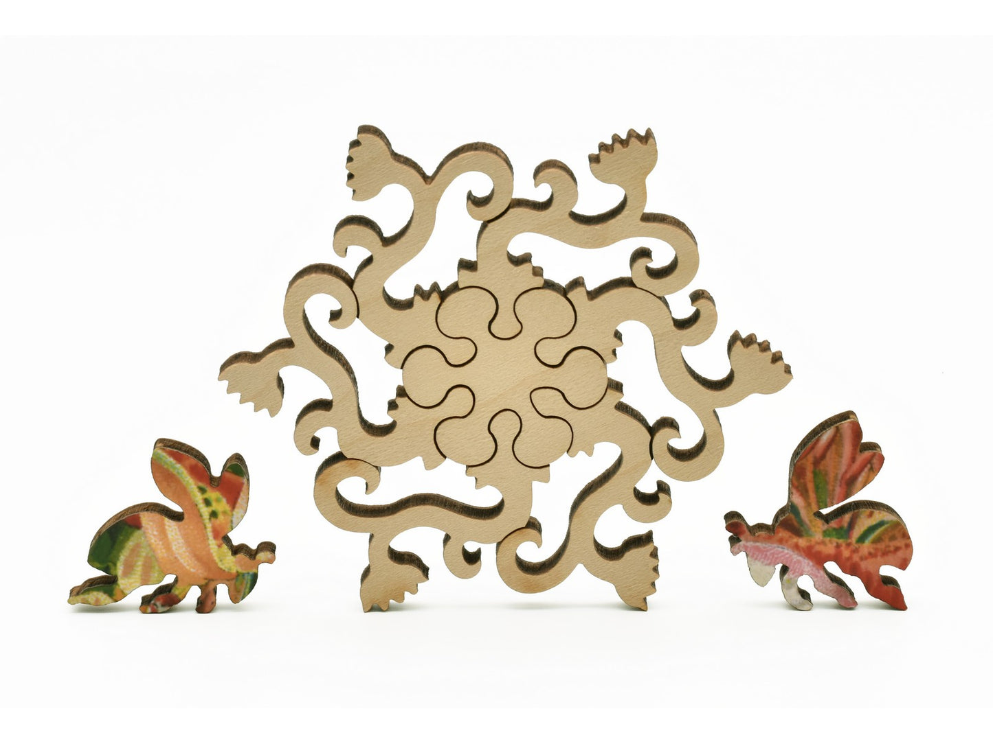 A closeup of pieces in the shape of a flowering vine and bees.