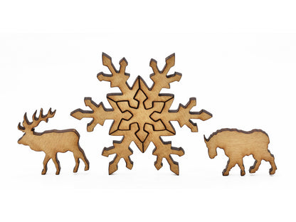 A closeup of pieces in the shape of a snowflake, an elk, and a mountain goat.