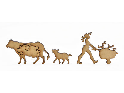 A closeup of pieces in the shape of a cow, a pig, and a person pushing a wheelbarrow.