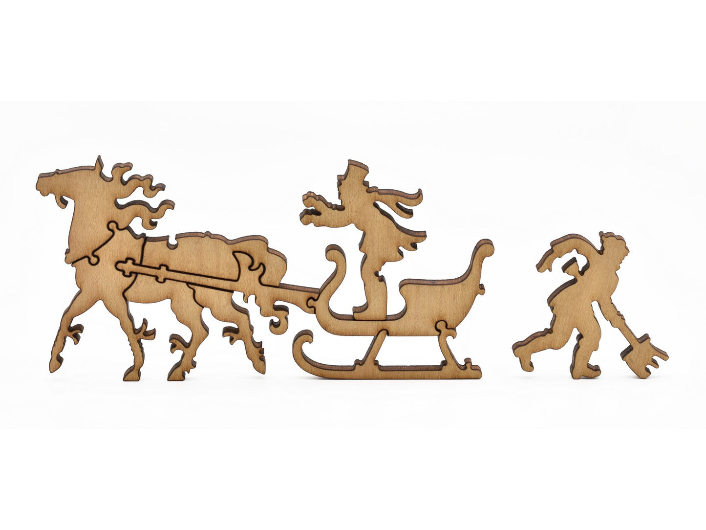 A closeup of pieces in the shape of a person driving a horse drawn sleigh and a person shoveling snow.