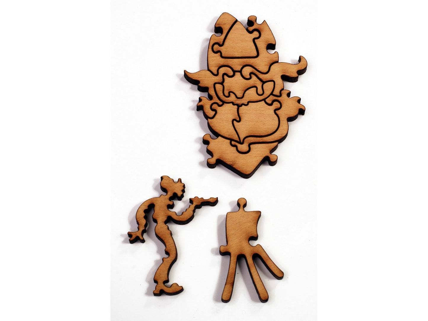 A closeup of pieces in the shape of a man painting at an easel.