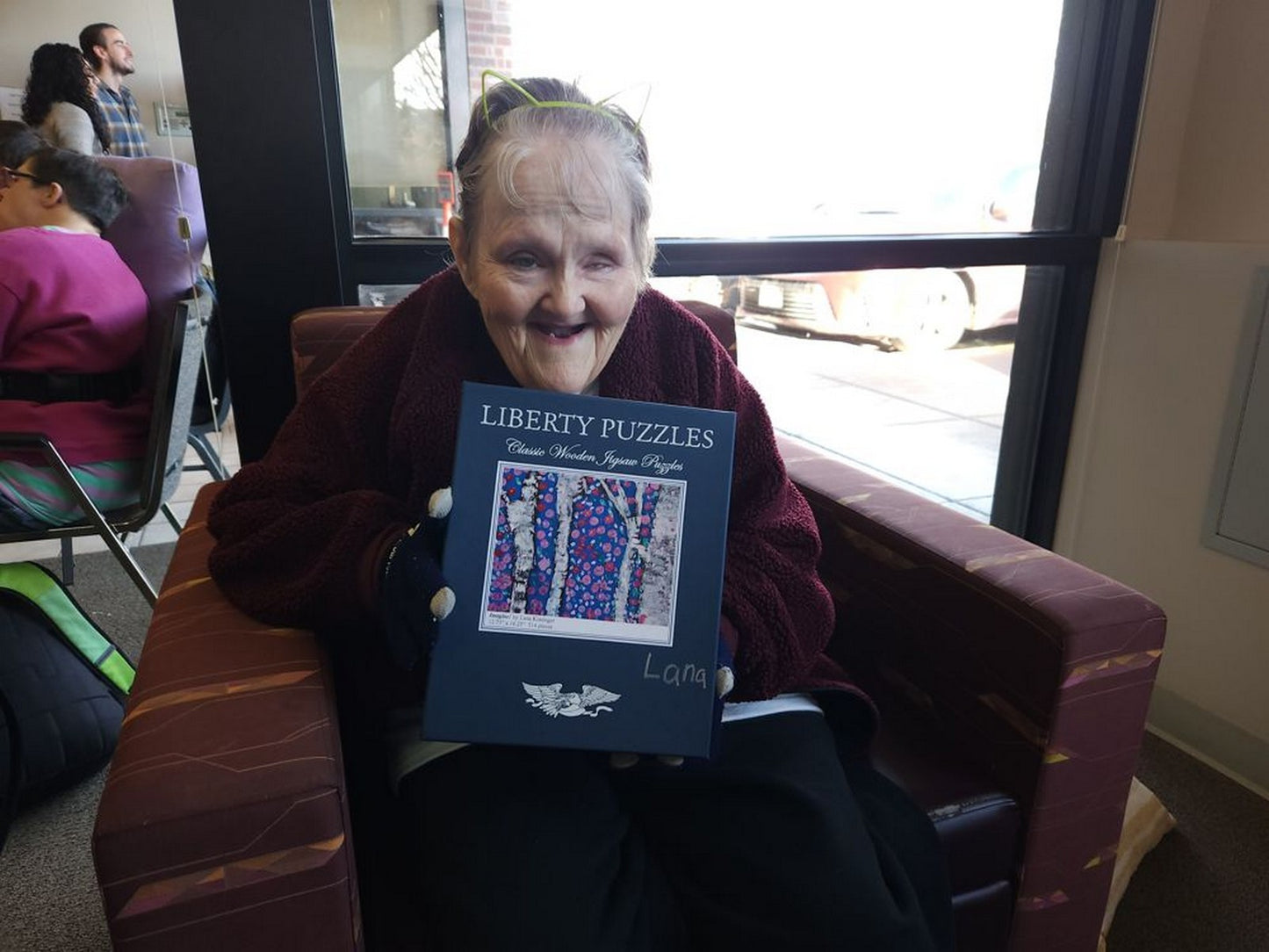 The artist, Lana Kissinger, holding the puzzle box displaying her art.