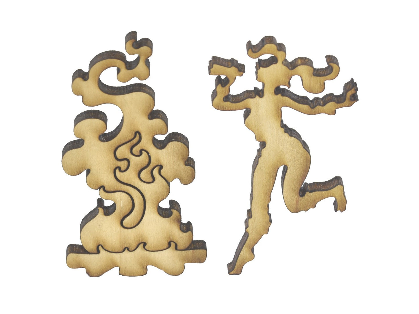 A closeup of pieces in the shape of woman by a campfire.