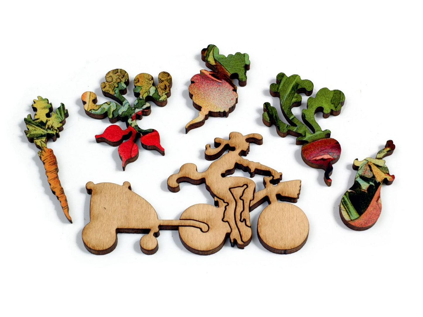 A closeup of whimsy pieces, picturing a woman on a bicycle, and assorted vegetables. 