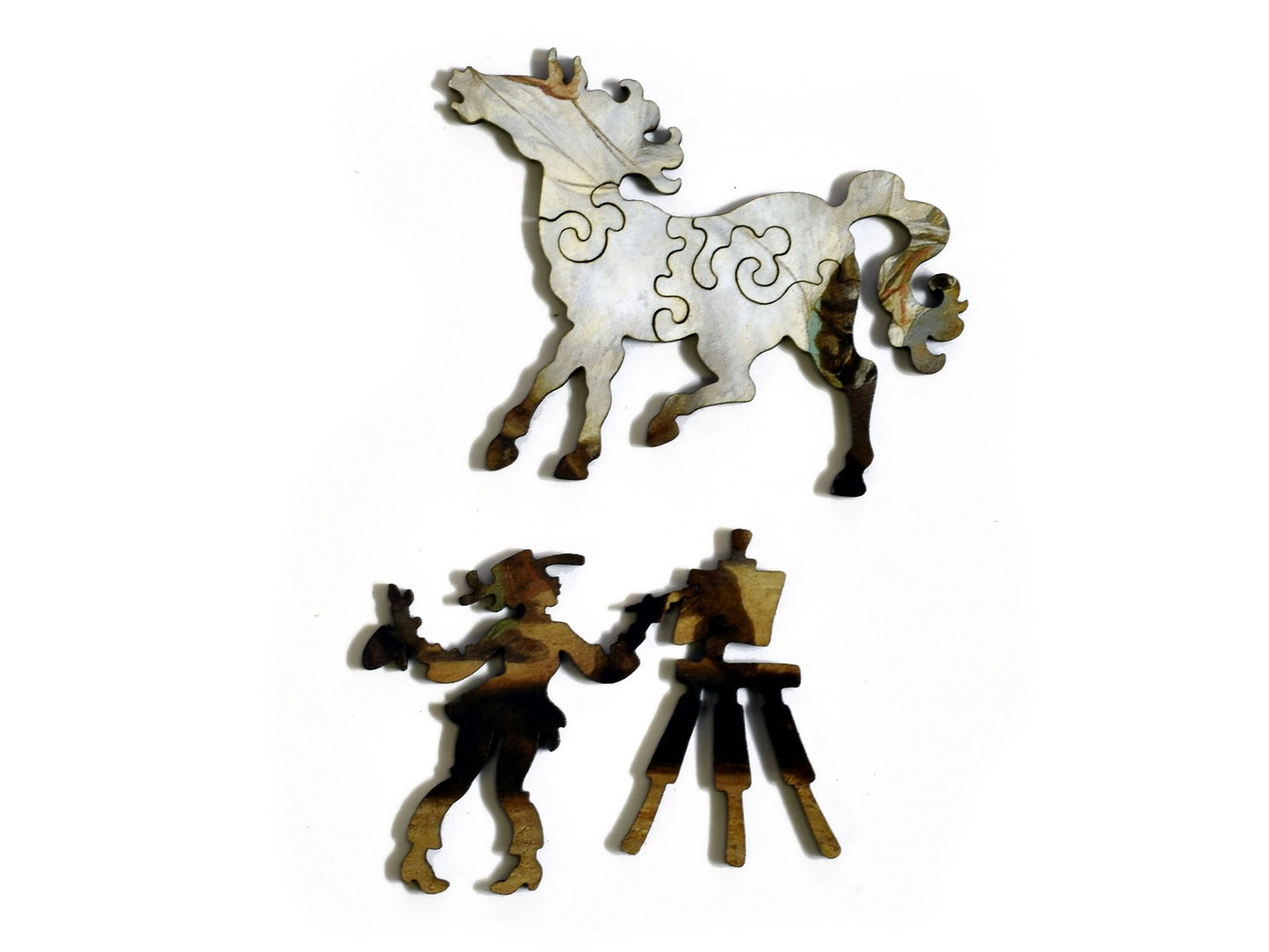 A closeup of pieces in the shape of a horse and an artist.