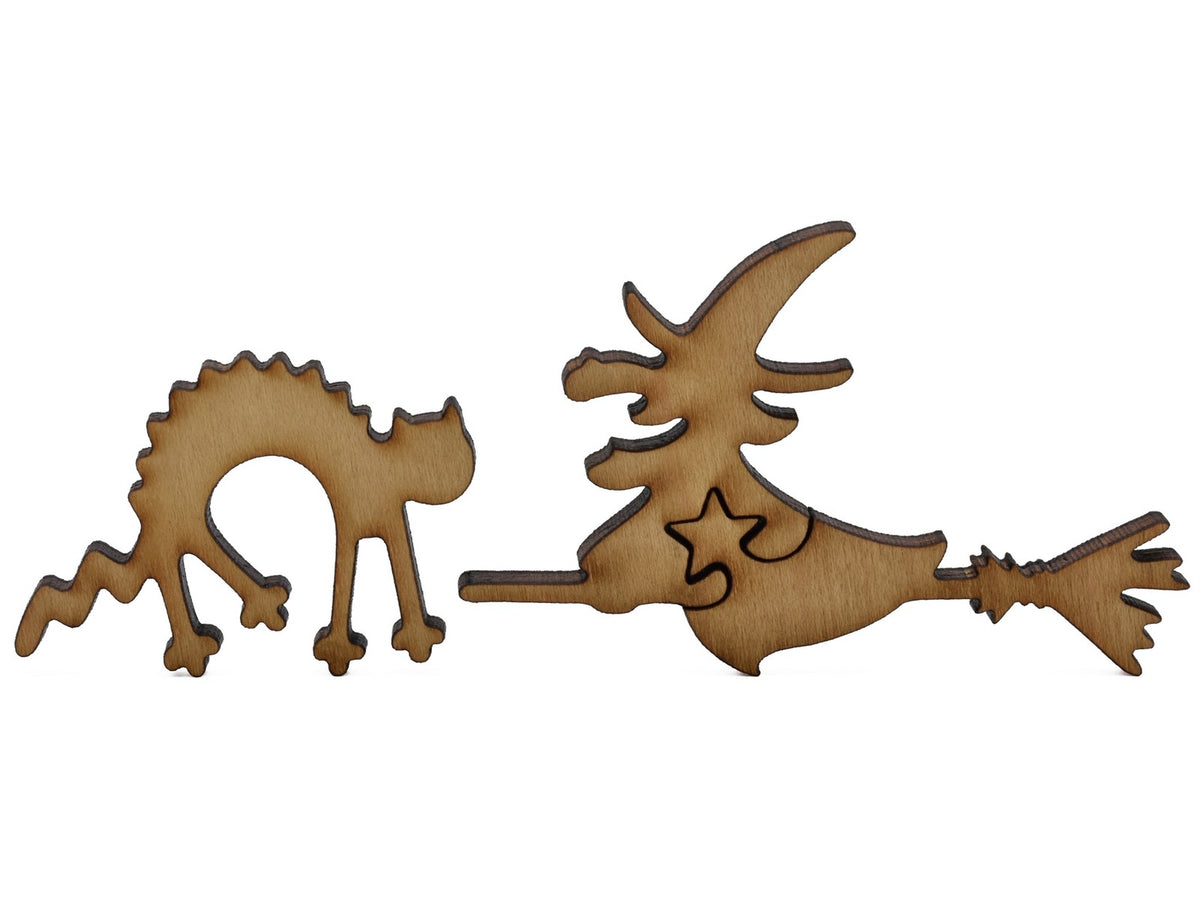 A closeup of pieces shaped like a cat and a witch on a broomstick.