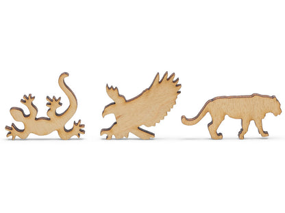 A closeup of pieces shaped like a lizard, eagle, and big cat.