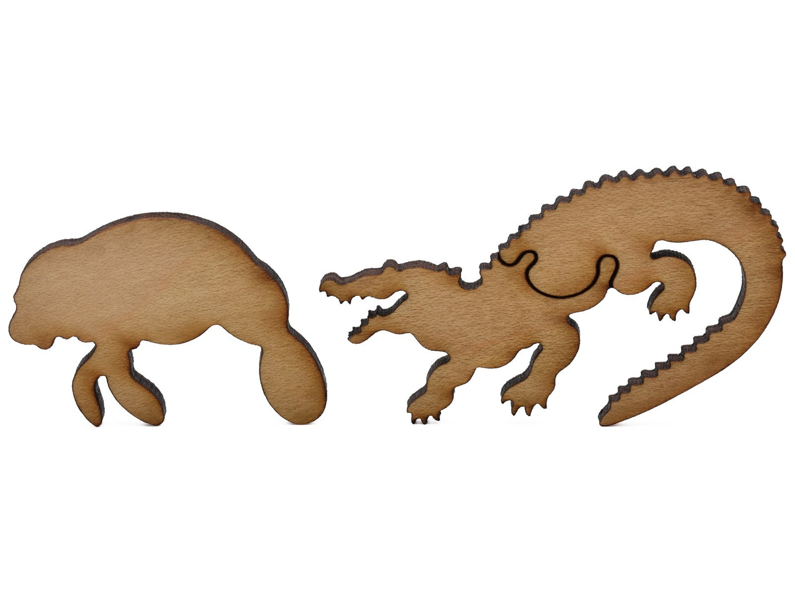 A closeup of pieces shaped like a manatee and an alligator.