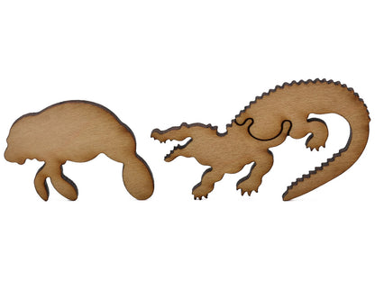 A closeup of pieces shaped like a manatee and an alligator.
