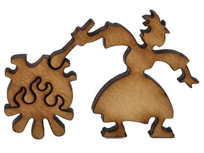 A closeup of pieces shaped like a person with a cauldron on a fire.