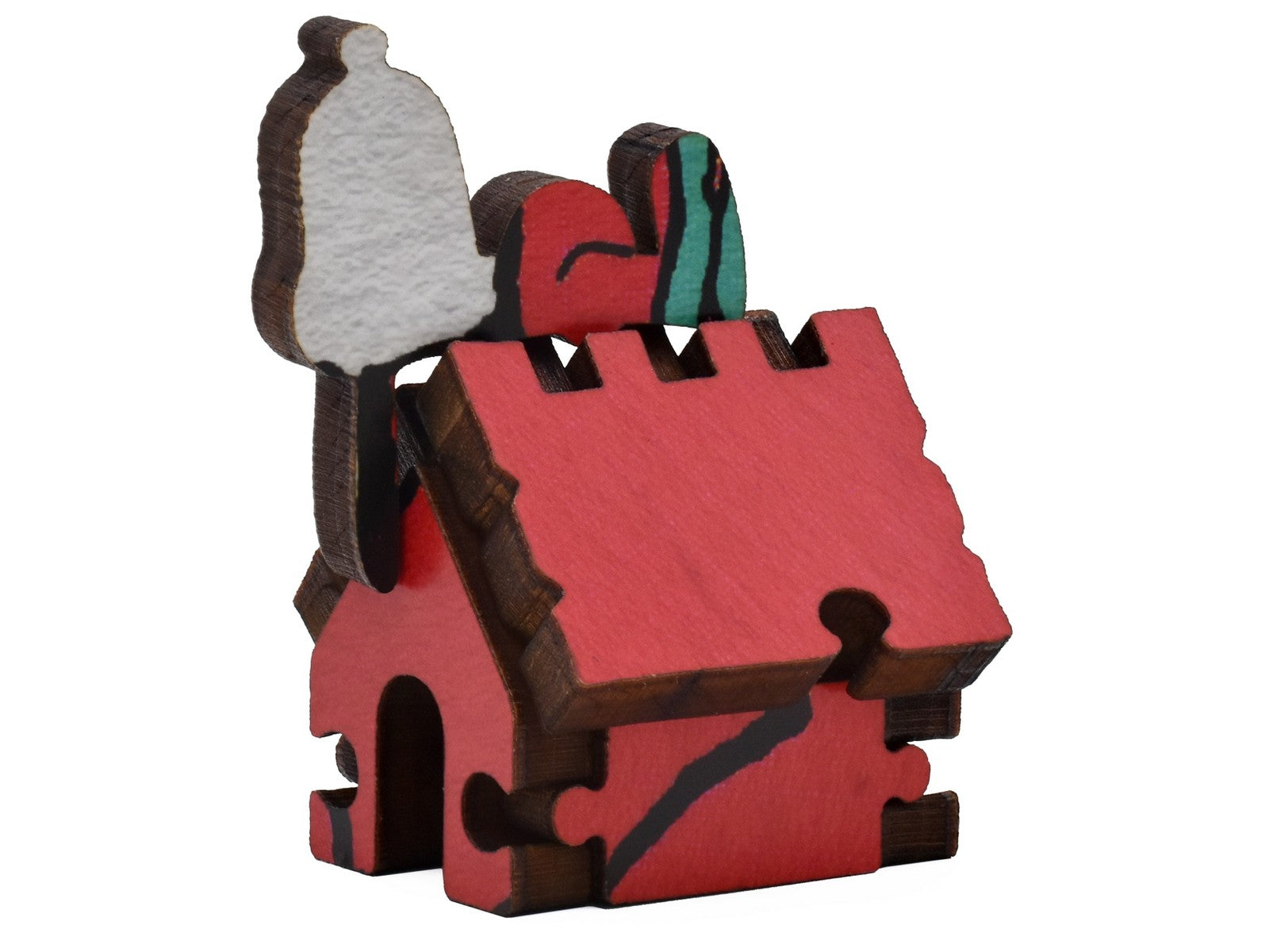 A closeup of pieces shaped like snoopy sleeping on top of his dog house.