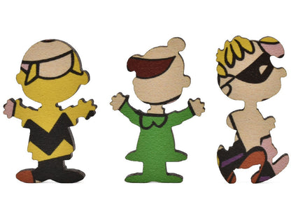 A closeup of three pieces shaped like Peanuts characters.