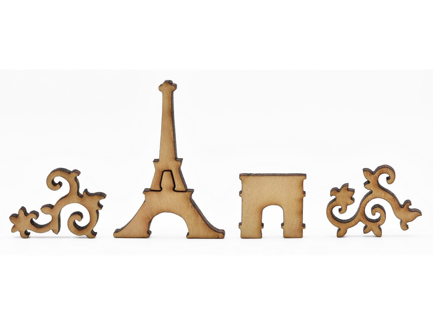 A closeup of pieces in the shape of the Eiffel tower and the arc de triomphe.