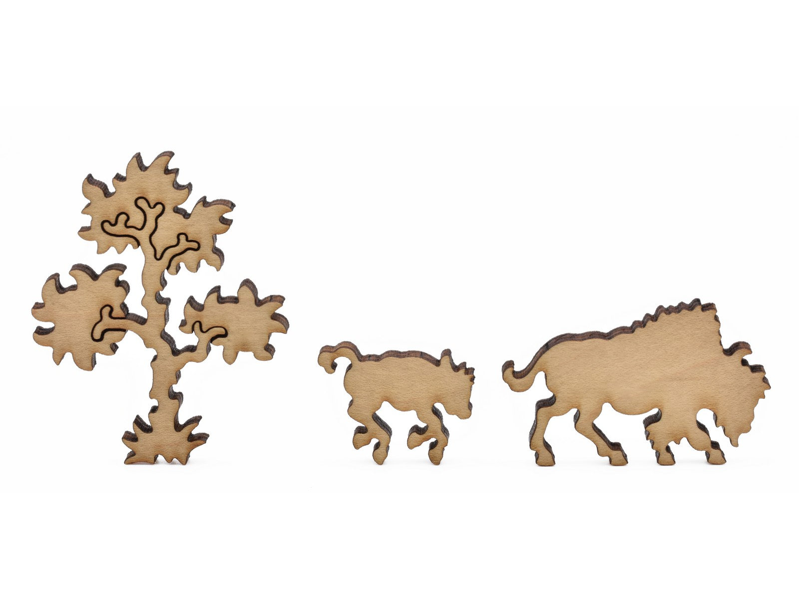 A closeup of pieces in the shape of a tree, a bison, and it's calf.