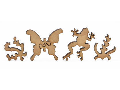 A closeup of pieces in the shape of a butterfly, a frog, and plants.