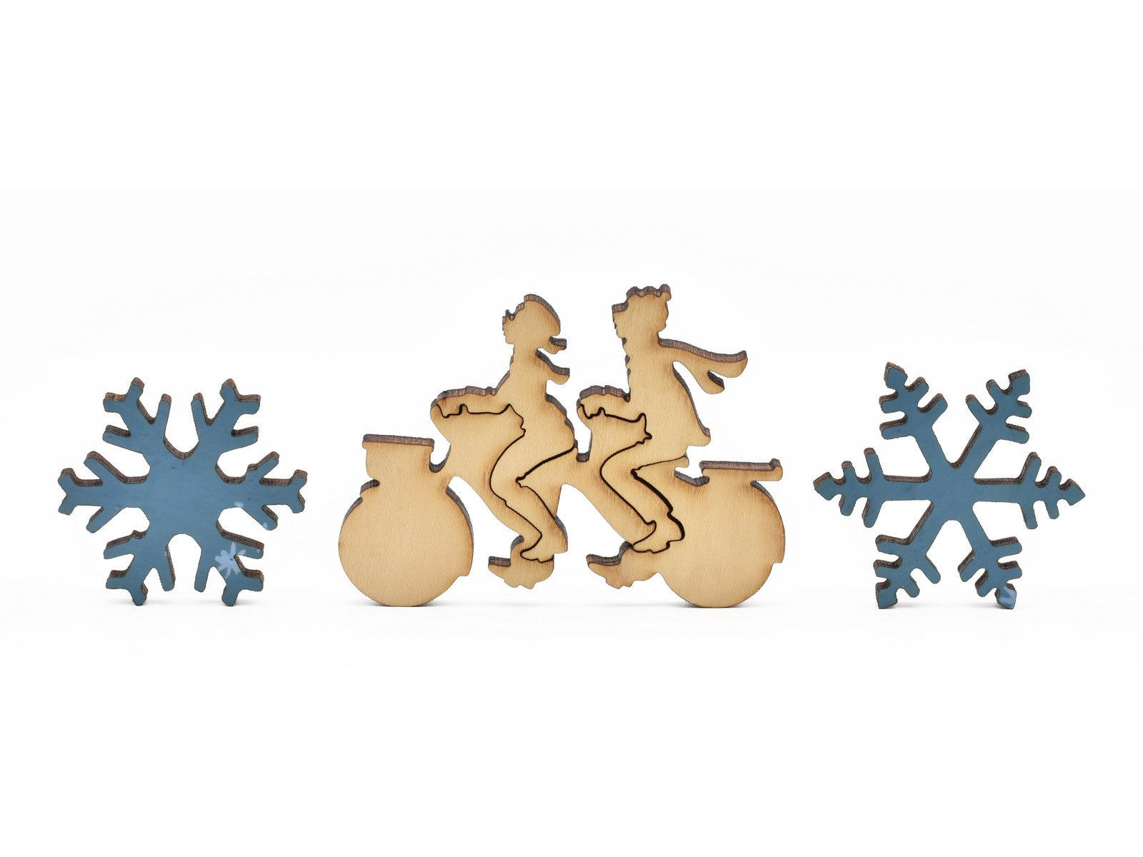A closeup of pieces in the shape of snowflakes and people riding a tandem bike.