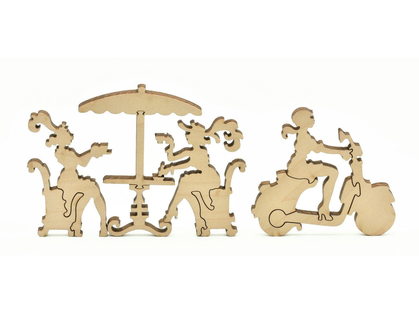 A closeup of pieces in the shape of people at a cafe and a woman riding a scooter.