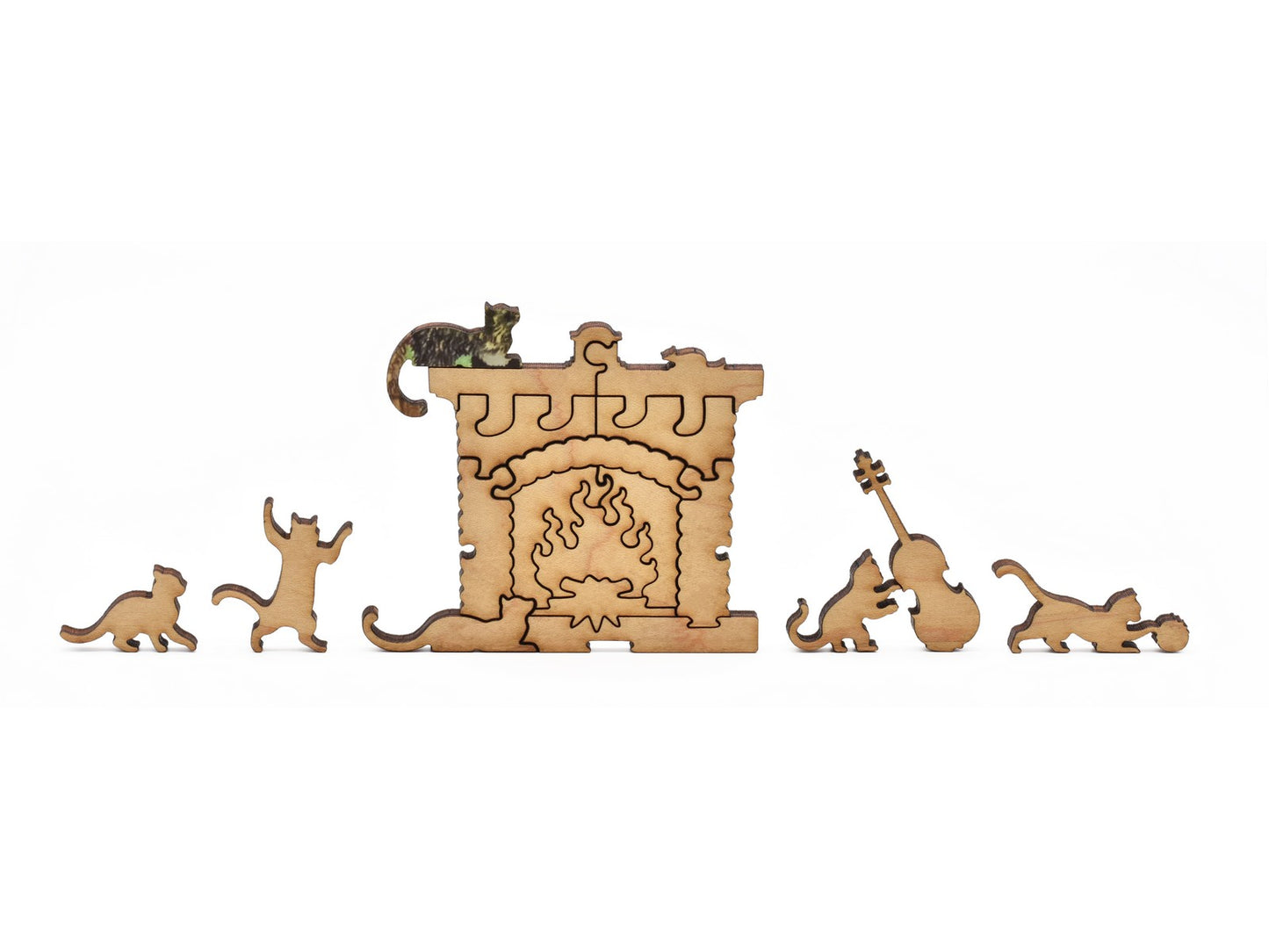 A closeup of pieces in the shape of cats around a fireplace.