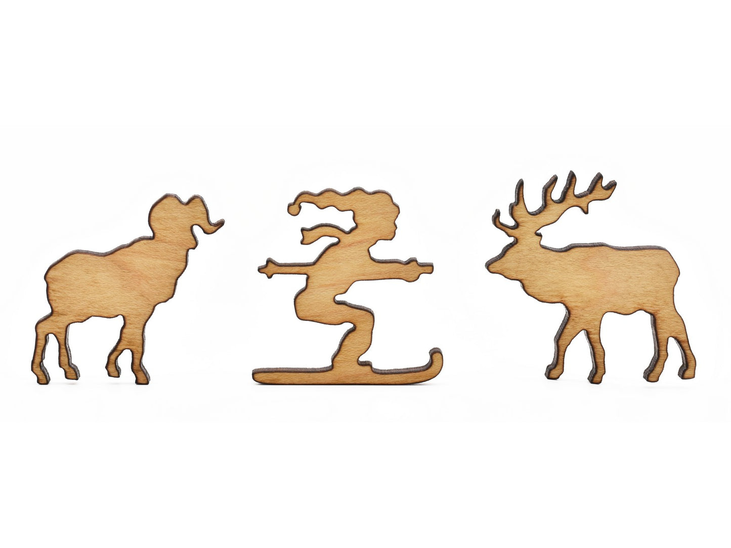 A closeup of pieces in the shape of a ram, a skier, and an elk.