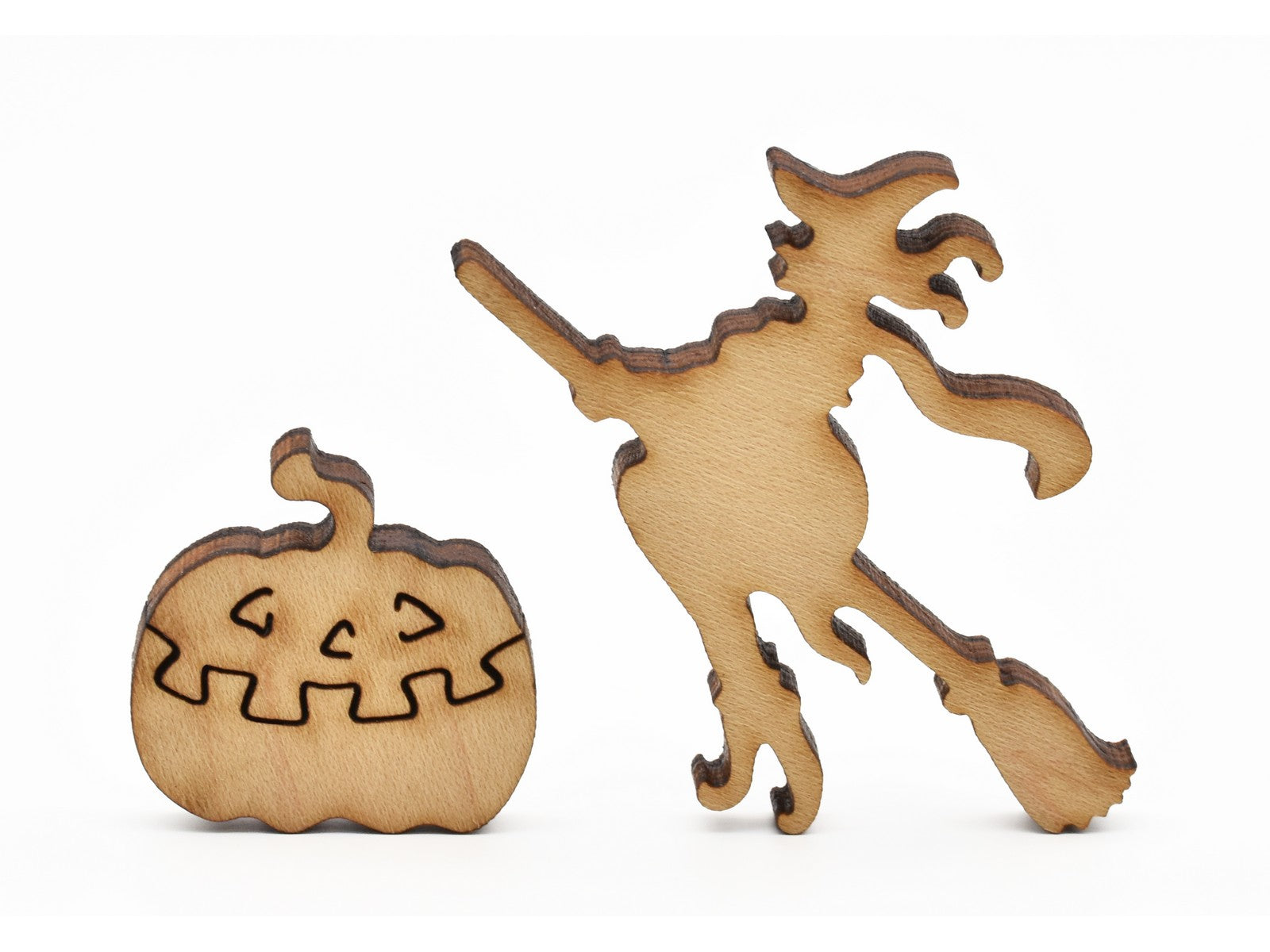 A closeup of pieces in the shape of a witch and a jack-o-lantern.