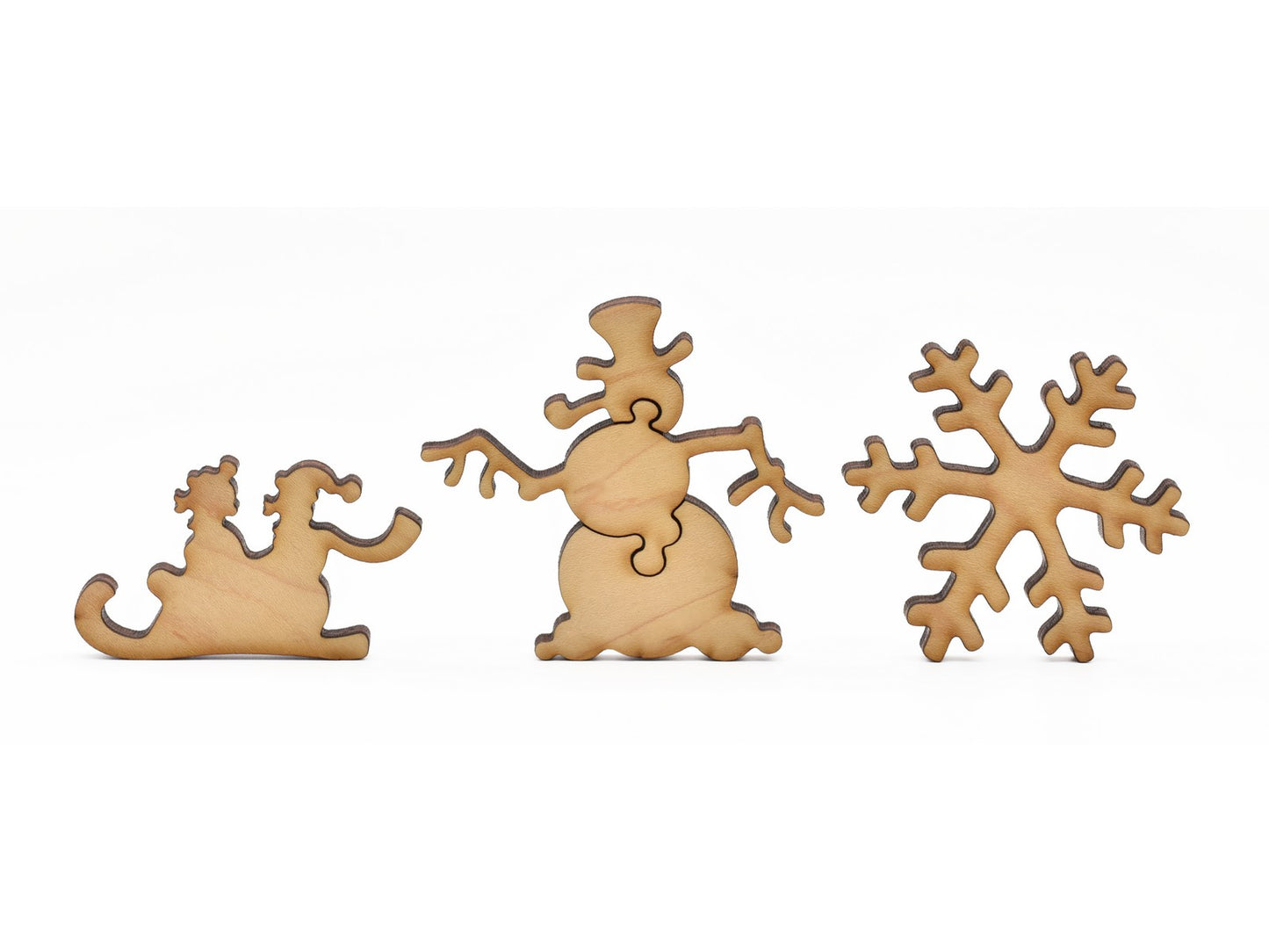 A closeup of pieces in the shape of a sled, a snowman, and a snowflake.
