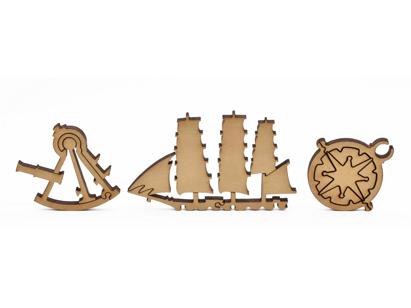 A closeup of pieces in the shape of a sextant, a ship, and a compass.