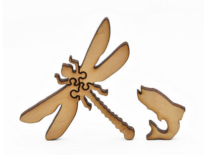 A closeup of pieces in the shape of a dragonfly and a fish.