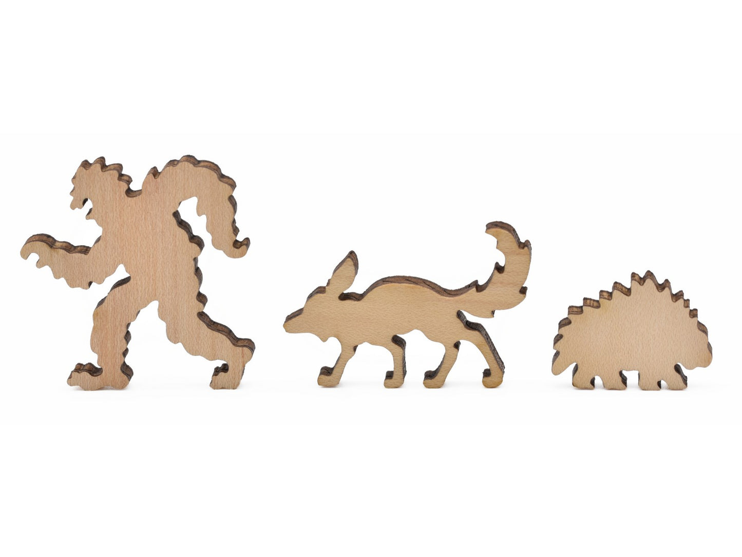 A closeup of pieces in the shape of bigfoot, a fox, and a porcupine. 