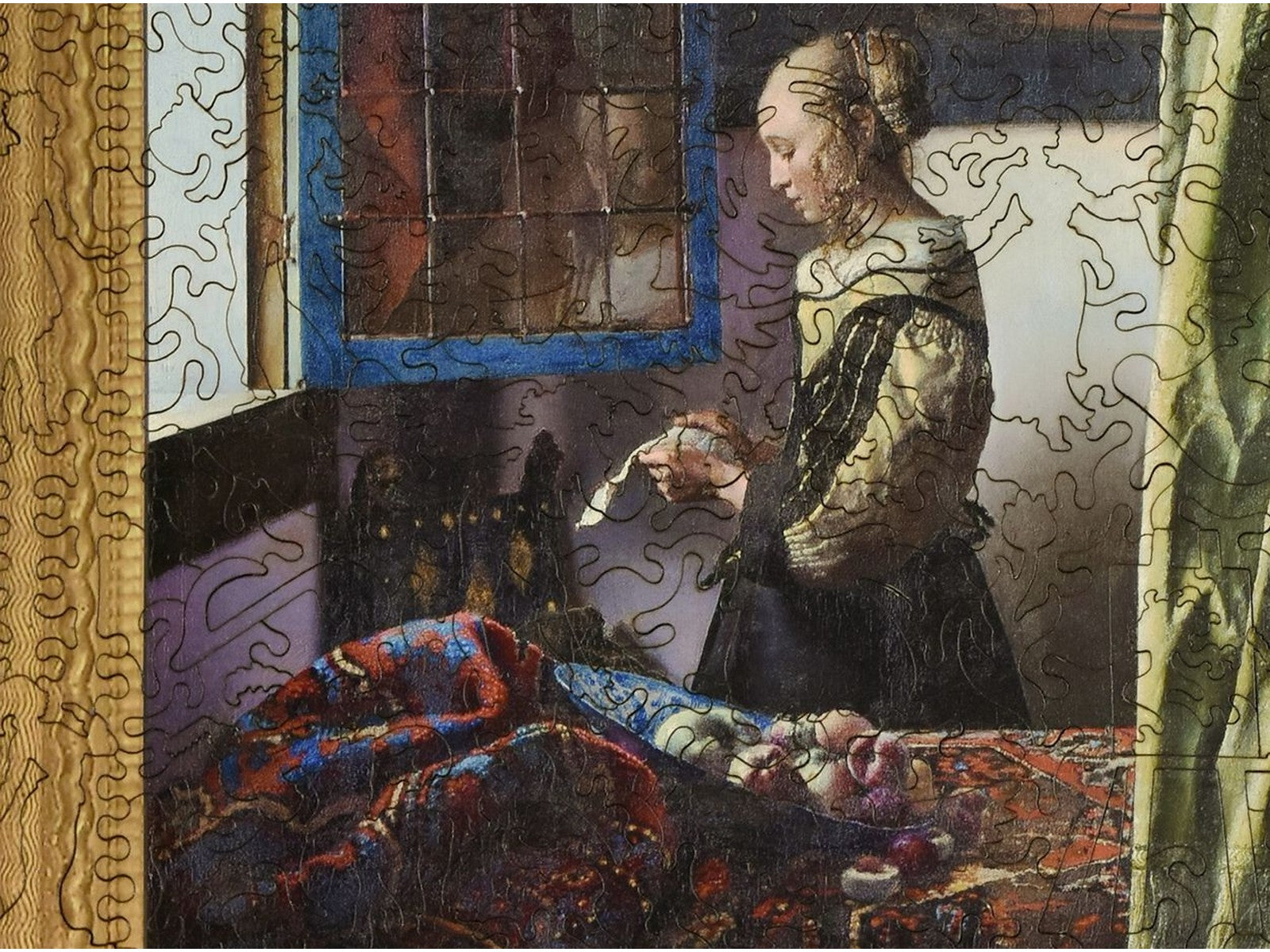 A closeup of the front of the puzzle, Girl Reading a Letter by an Open Window, showing the detail in the pieces.