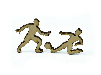 A closeup of pieces in the shape of two people playing soccer / football.