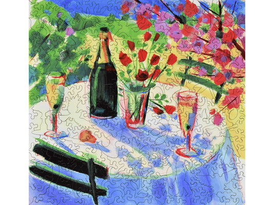 The front of the puzzle, Celebration, which shows a vase of flowers and champagne on a cafe table. 