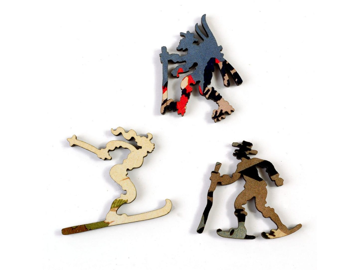 A closeup of pieces, in the shapes of three people skiing.