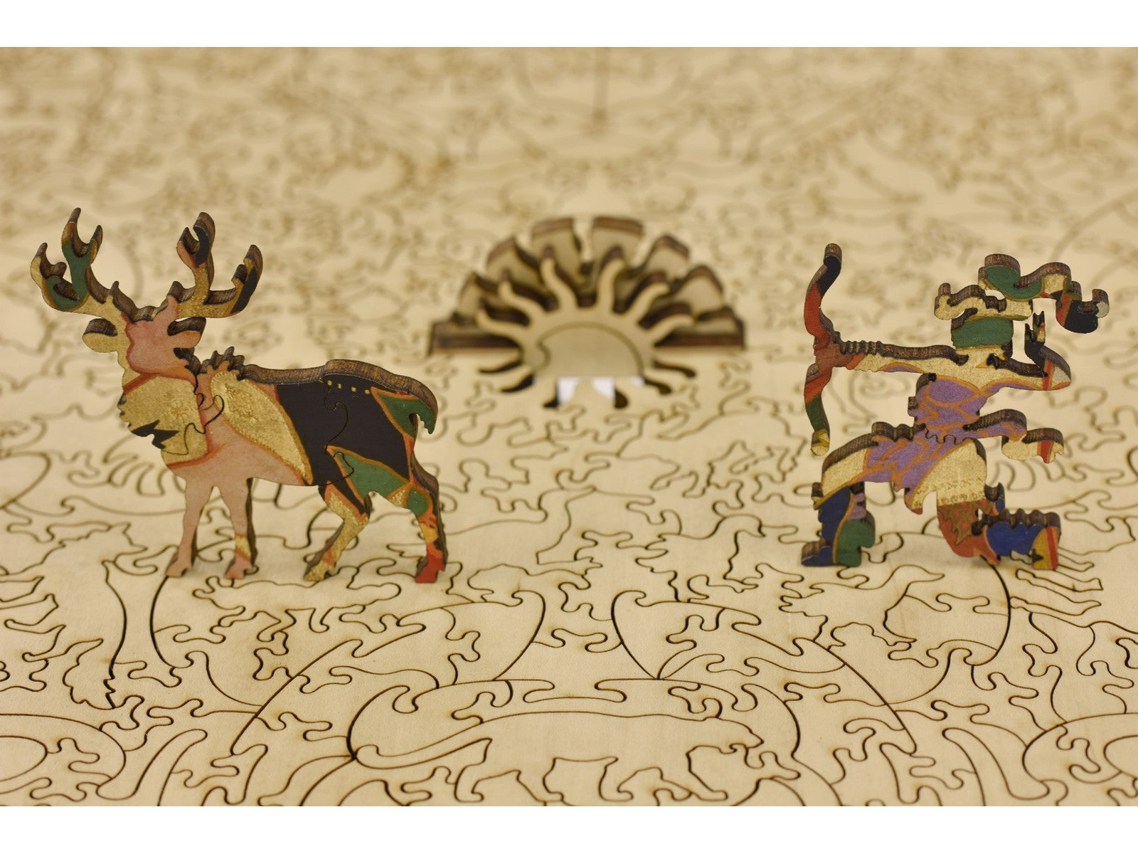 A closeup of pieces in the shape of a deer and a huntress sitting on the puzzle.