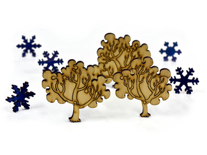 A closeup of pieces in the shape of trees and snowflakes.