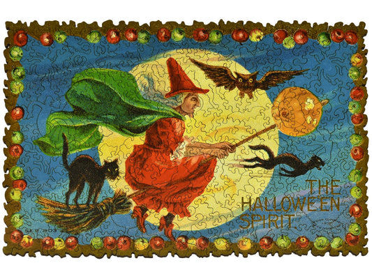 The front of the puzzle, Halloween Spirit, which shows a witch flying on a broomstick with two black cats.