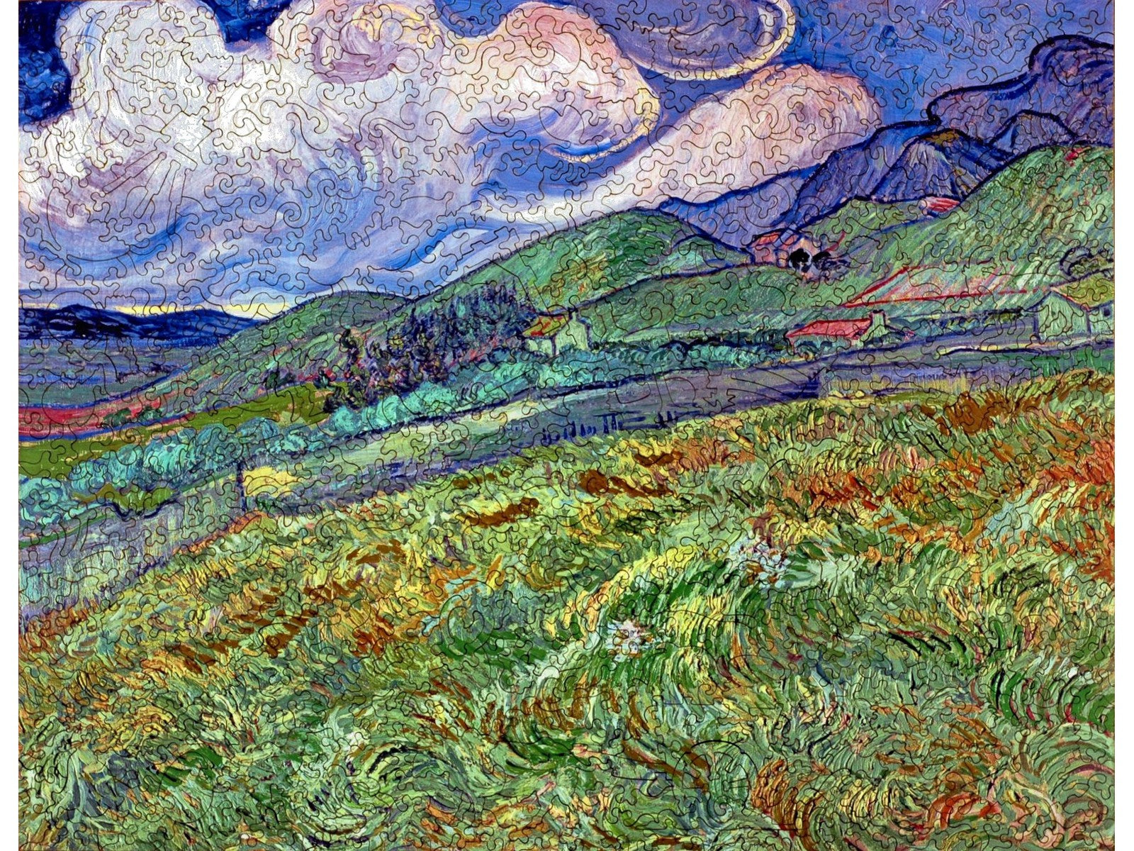 The front of the puzzle, Mountainous Landscape Behind Saint-Remy, showing a green field with blue mountains and a sky filled with clouds.