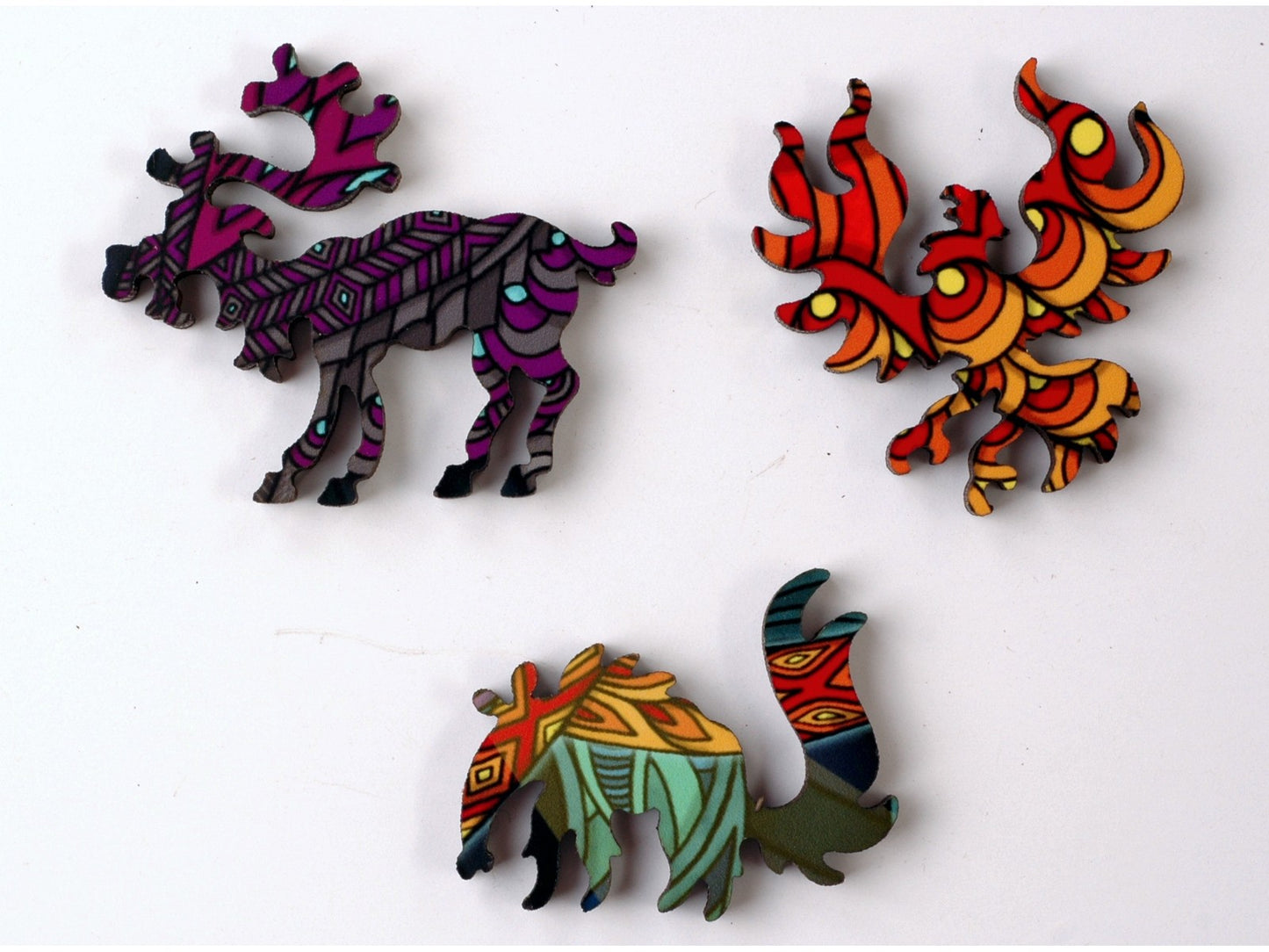 A closeup of pieces in the shape of a reindeer, a phoenix, and an anteater.