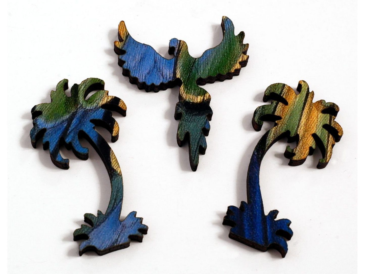 A closeup of pieces, in the shapes of a parrot, and two palm trees.