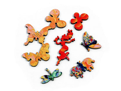 A closeup of pieces in the shape of a person smelling a flower and butterflies.