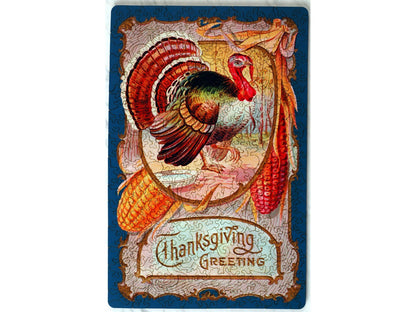 The front of the puzzle, Thanksgiving Greeting, which shows a turkey surrounded by a decorative border with corn and the words, "Thanksgiving Greeting".