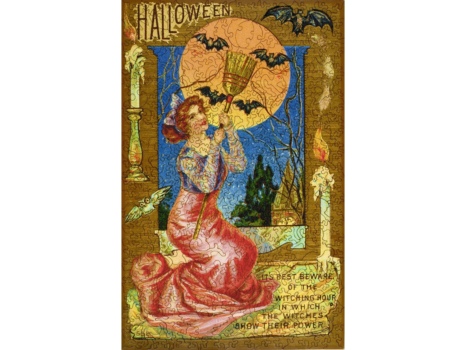 The front of the puzzle, The Witching Hour, which shows a woman holding a broom, surrounded by candles and bats.