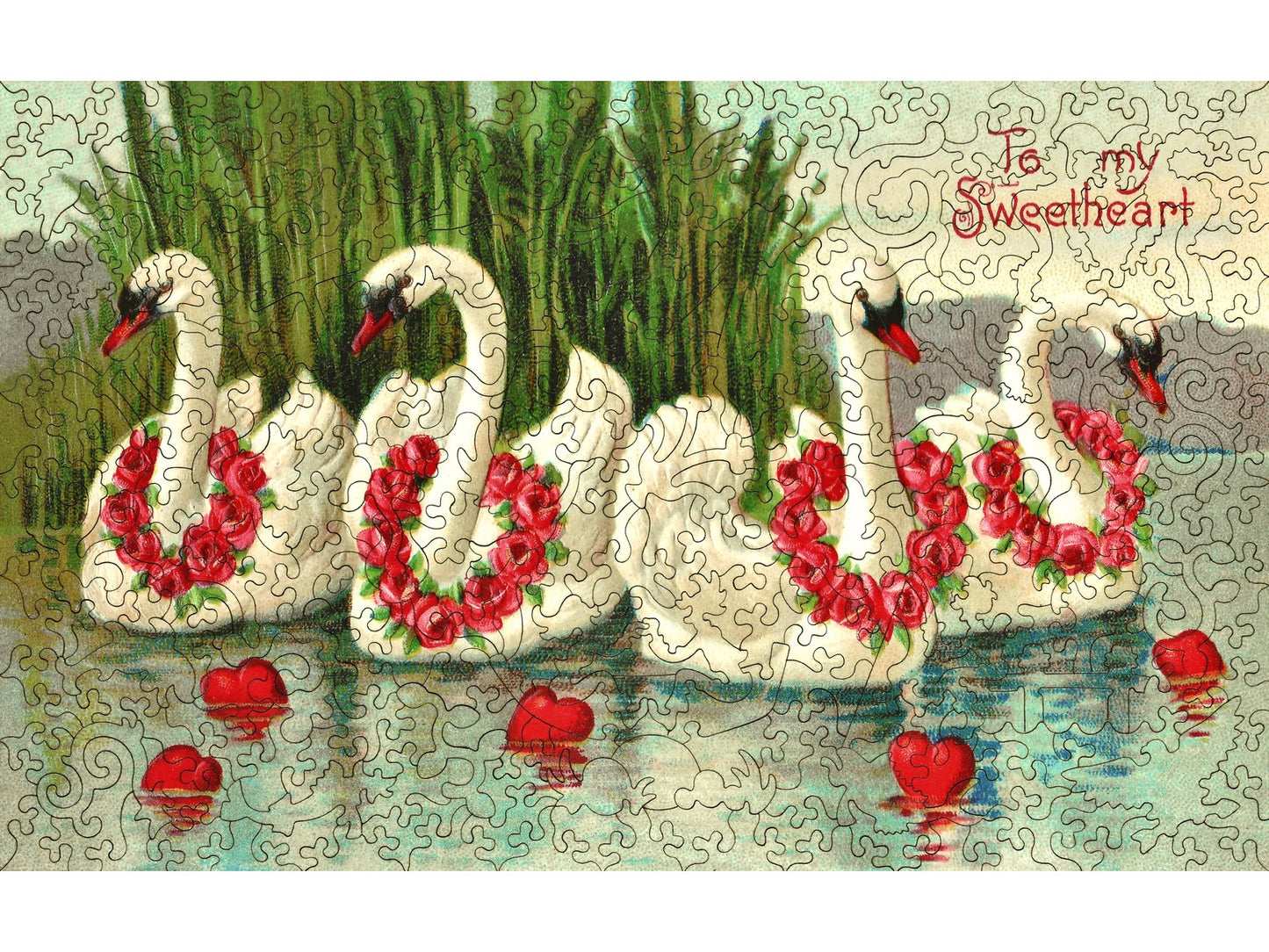 The front of the puzzle, Valentine Swans, which shows four swans in a lake with flower wreaths around their necks, and hearts floating in the water.